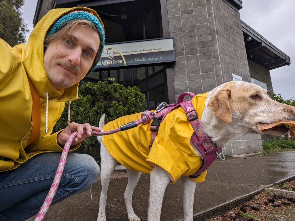 a photo of me and a dog outside wearing matching yellow raincoats